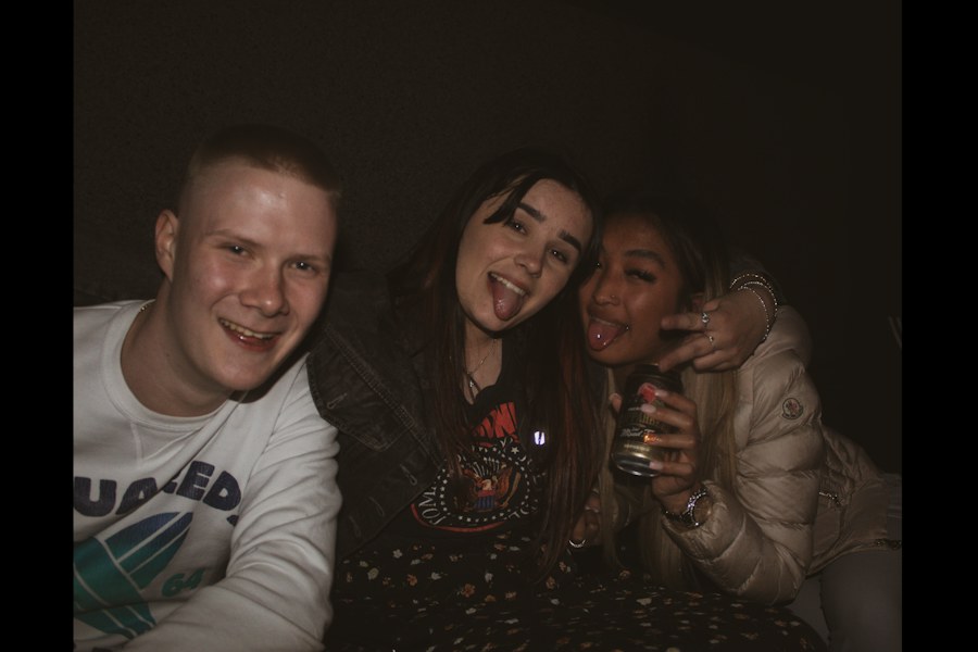 Three friends posing for a flash photo