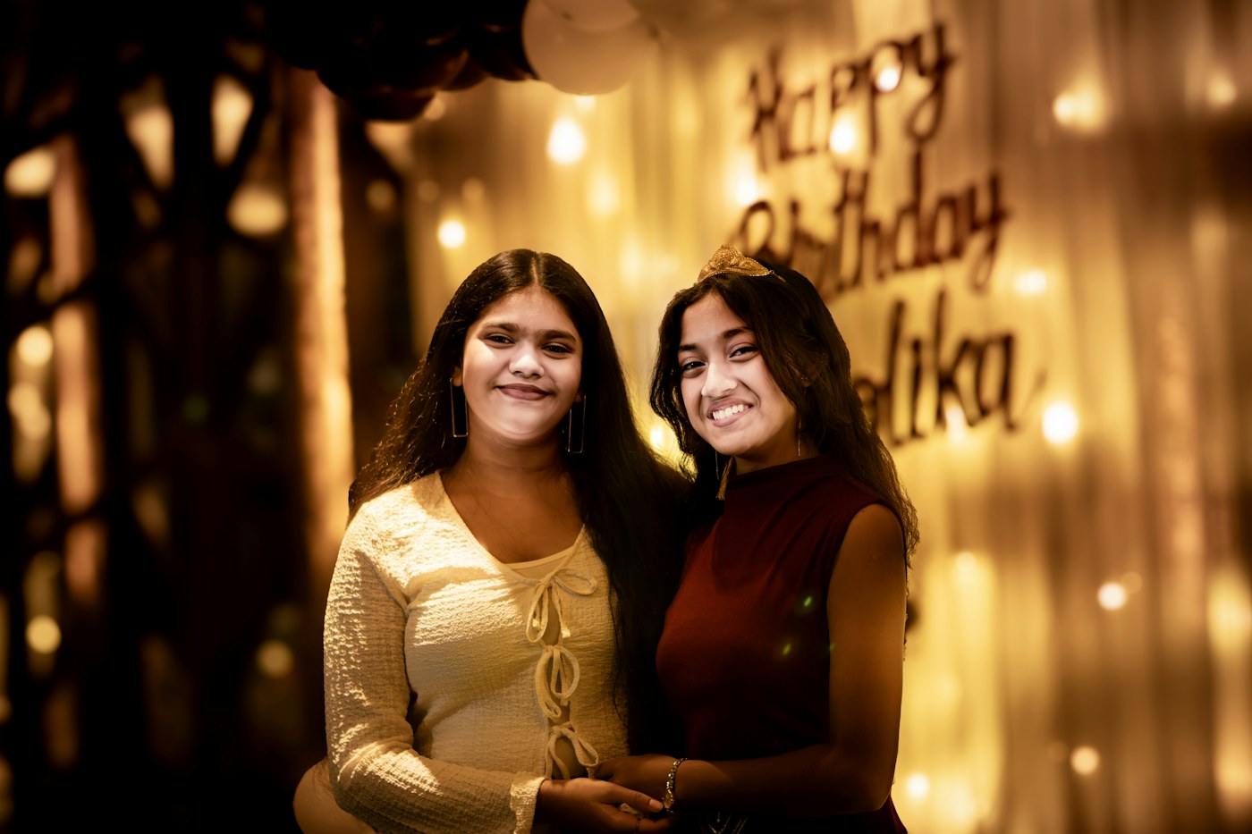 Two friends smiling at a birthday celebration